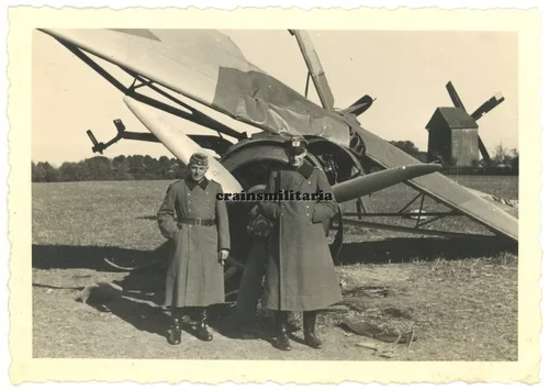 Offiziere mit Flugzeug Wrack bei Windmühle in Russland Polen Ukraine.webp